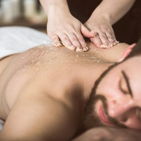 Man Relaxing During A Salt Scrub Beauty Therapy