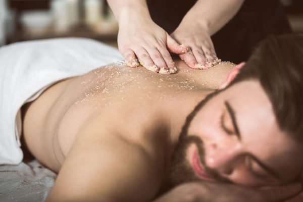 Man Relaxing During A Salt Scrub Beauty Therapy